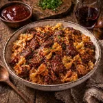 bbq beef bow tie pasta on rustic wooden table