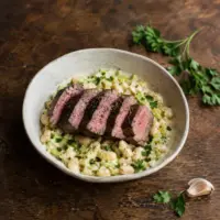 Sliced seared steak served over creamy butter beans, leeks and parsley.