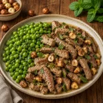 Air Fryer Mint Lamb Hazelnuts served on a rustic wooden table with peas and toasted hazelnuts