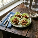 air fryer pork lettuce wraps with orange ginger sauce on a rustic wooden table