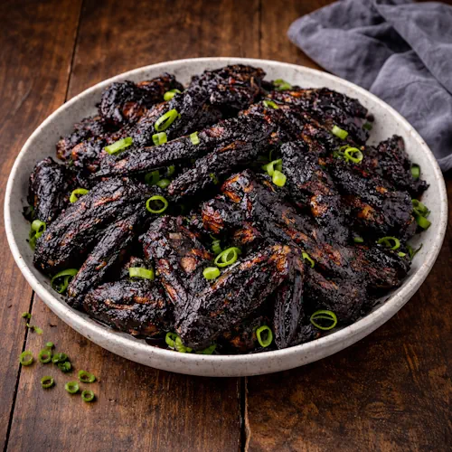 Barbecued Bat Wings on a rustic wooden table.