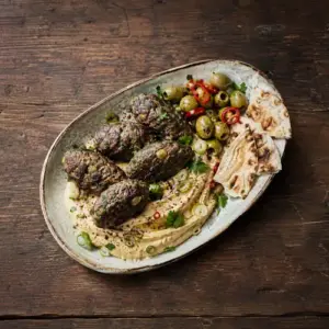 Beef koftas with green olives, hummus, flatbread, parsley and sumac.