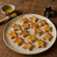Golden butter-brushed star-shaped toast bases on a rustic wooden table.