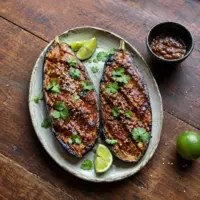 Caramelised miso-glazed eggplant with sesame seeds, coriander and lime.